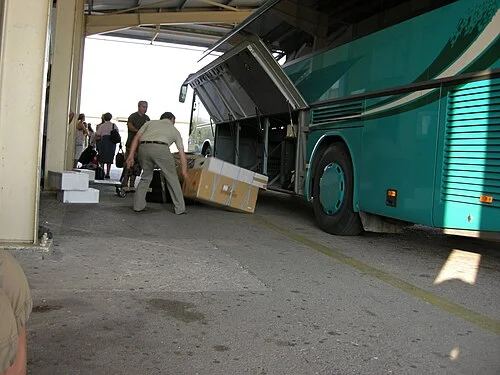 Postsendungen werden aus dem Gepäckraum eines Busses in Griechenland entladen